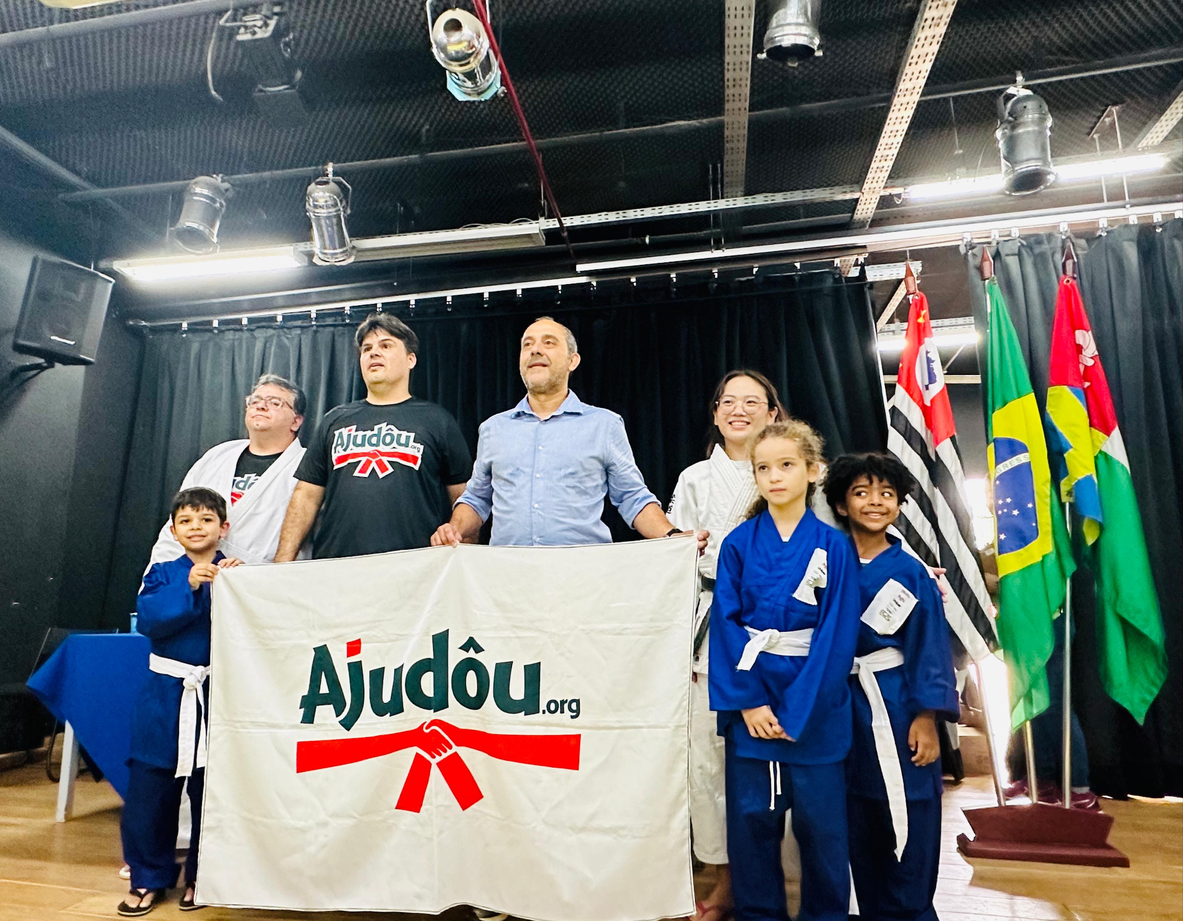 Prefeito Guto Volpi, representantes da ONG Ajudôu e alunos durante cerimônia